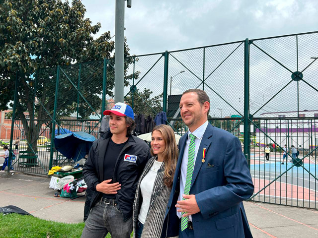 Aliados del proyecto de arte urbano en Bogotá posan frente a la reja de un parque